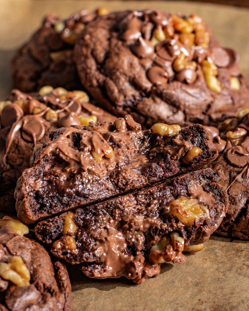 Eggless NYC chocolate walnut cookie broken open showing soft inside
