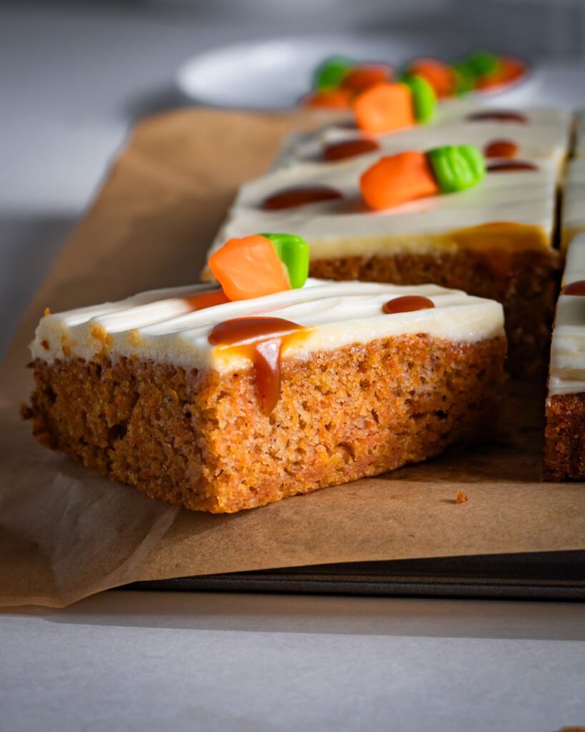 vegan eggless carrot sheet cake topped with smooth frosting close up