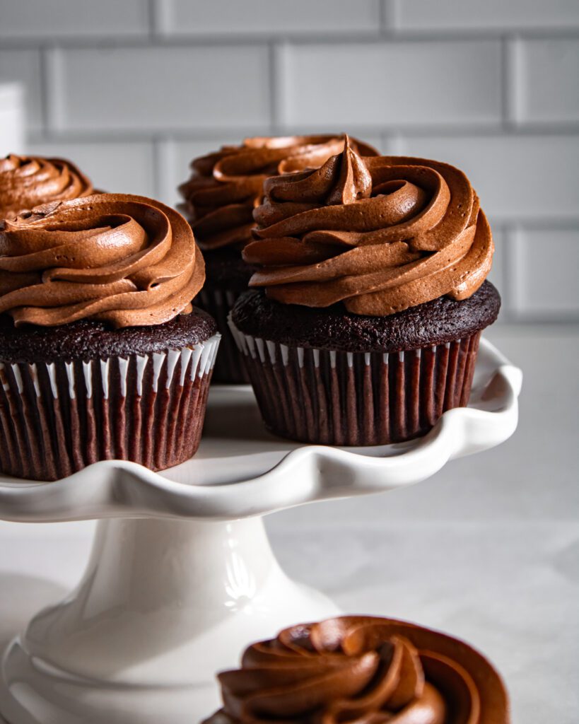 Eggless chocolate cupcakes topped with smooth chocolate icing