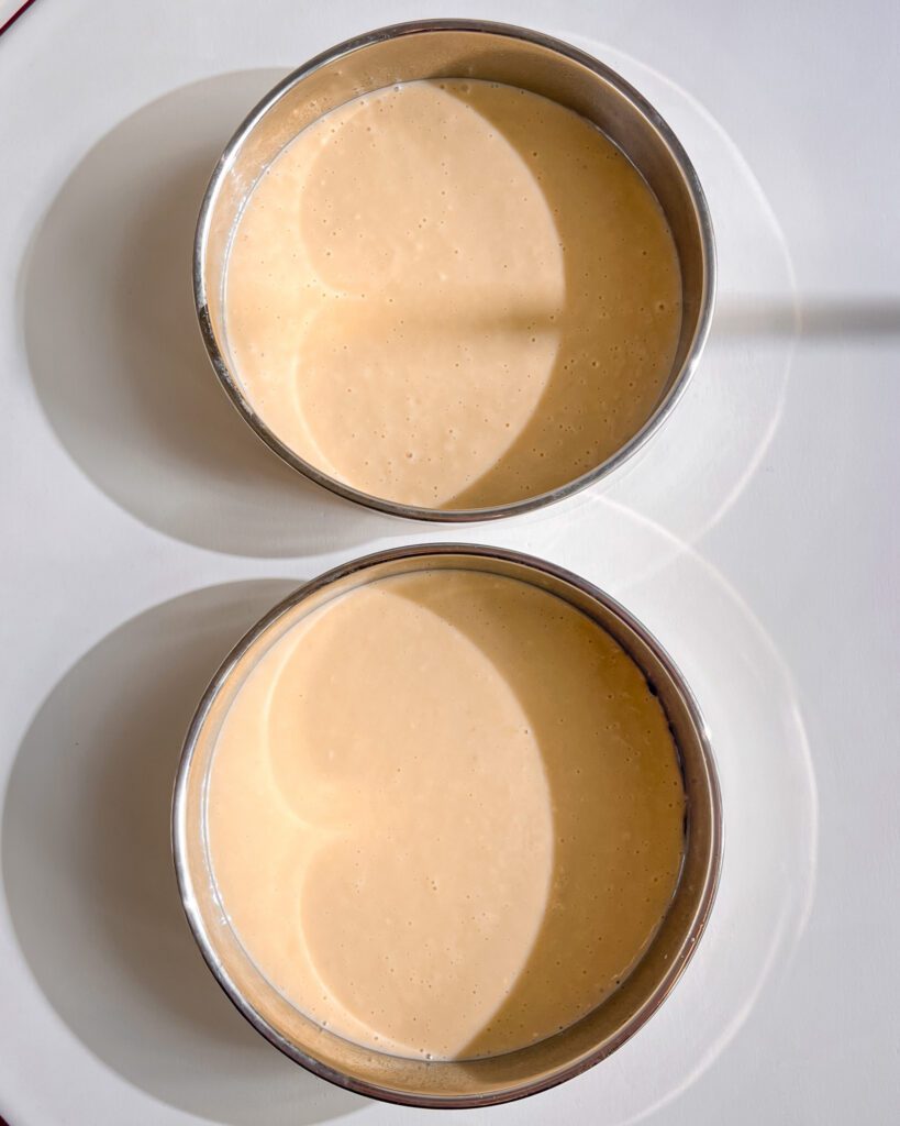 cake batter in cake pans ready to bake eggless vanilla cake