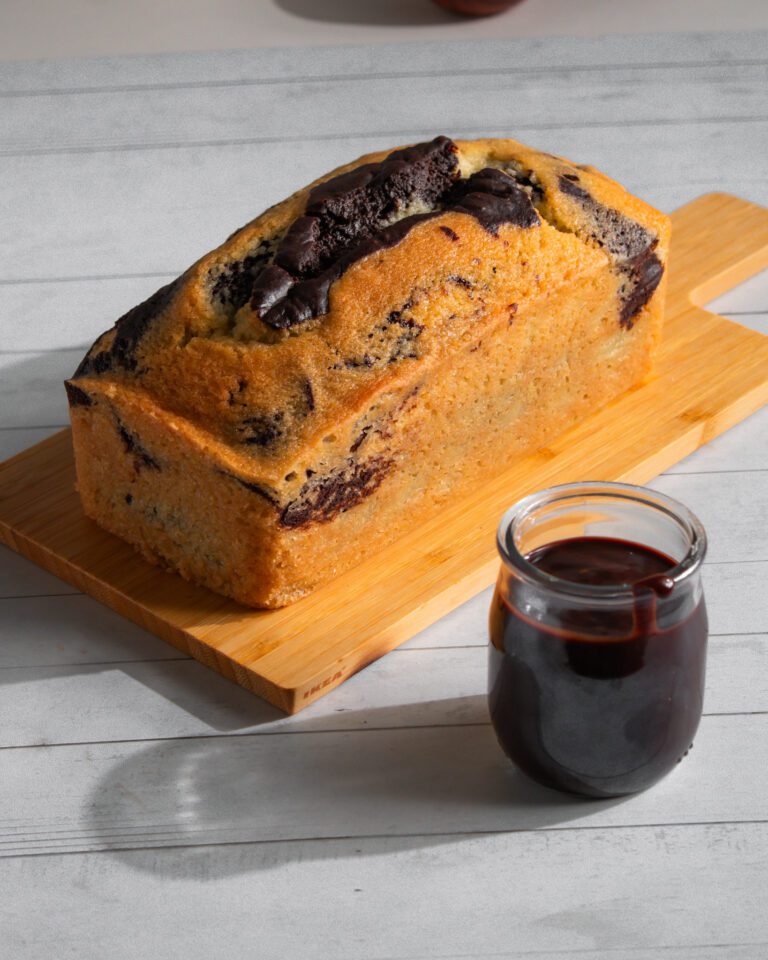 Freshly baked eggless marble loaf cake with chocolate topping