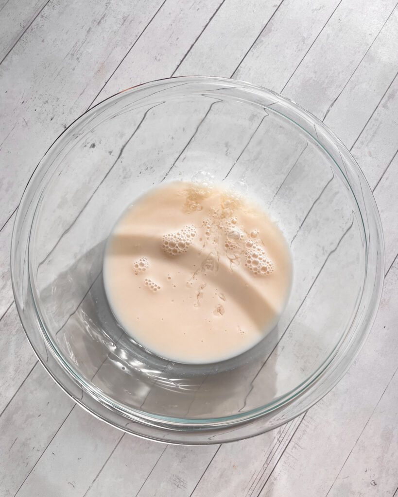Milk for eggless cinnamon cake measured in a bowl