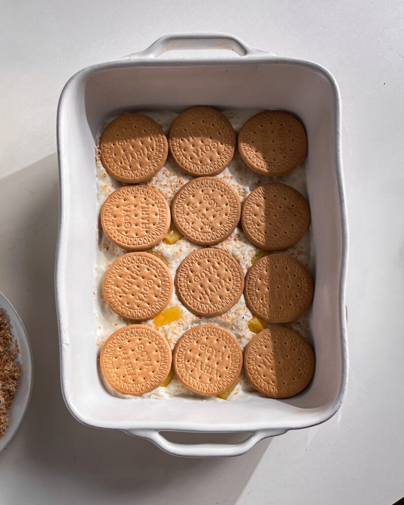 Building layers of biscuits and pineapple coconut cream