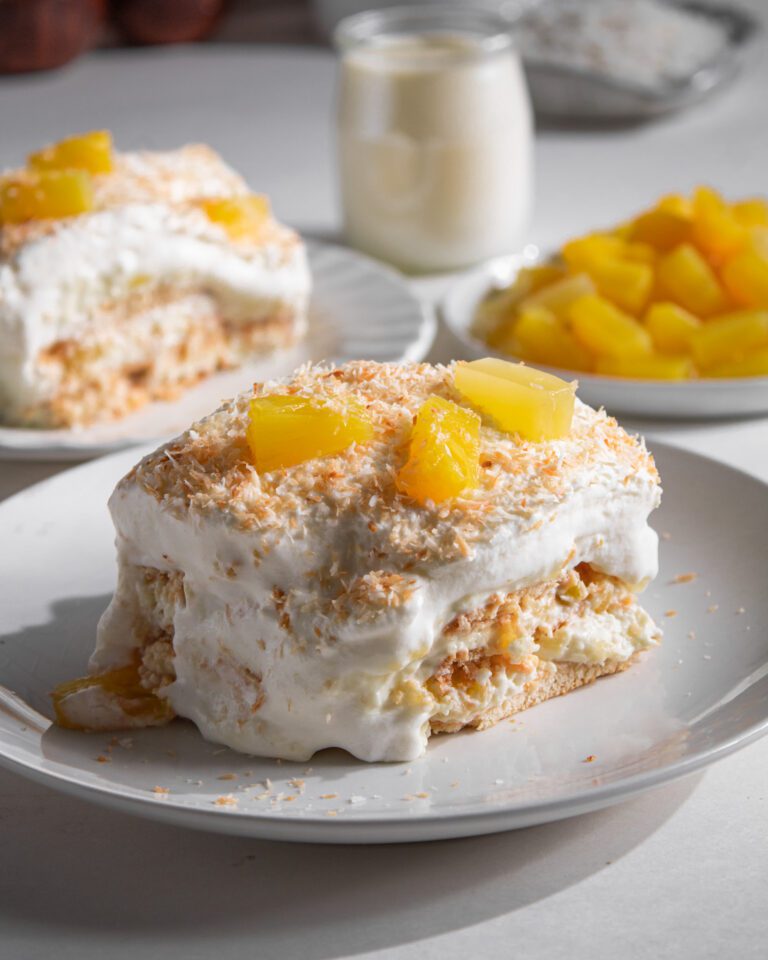 Close-up of a slice of no-bake pineapple coconut cake showing the creamy layers.