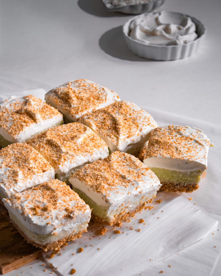 Creamy coconut cream pie bars with a biscuit crust and vanilla whipped cream.