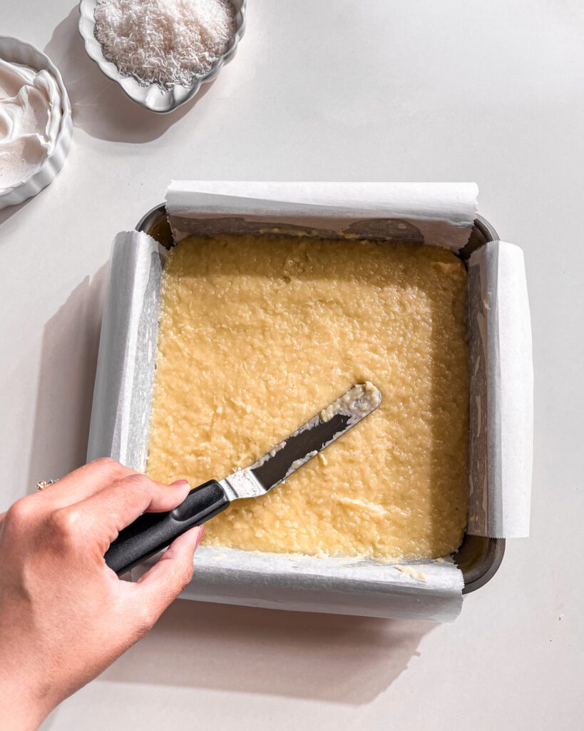Spreading the coconut custard evenly across the crust.