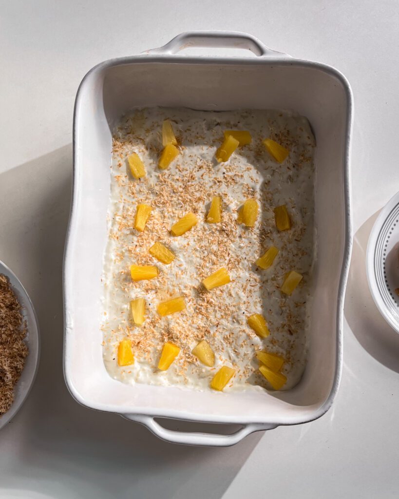 Sprinkling toasted coconut and pienapple over the pudding layer