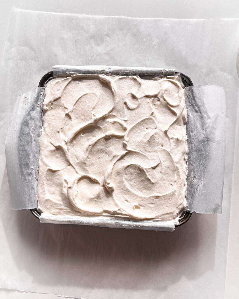 Sprinkling toasted coconut over the whipped cream topping.