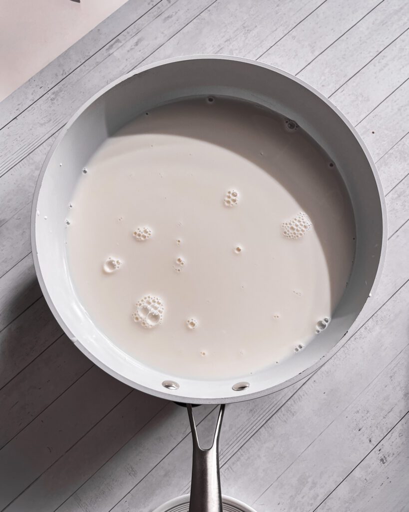 Whisking cornstarch, sugar, and milk to make pineapple coconut pudding