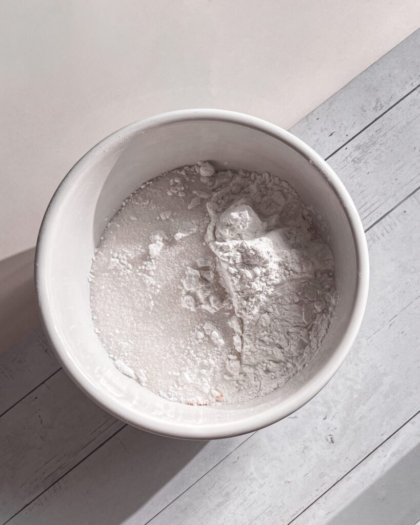 Whisking cornstarch, sugar to make vanilla pudding