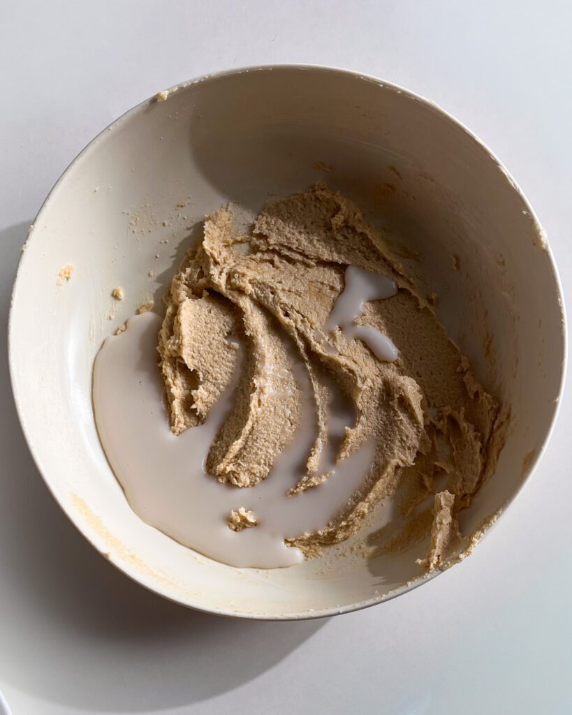 Adding milk and vanilla to chocolate chip cookie dough