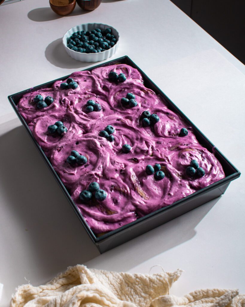 Freshly baked blueberry cinnamon rolls with blueberry frosting