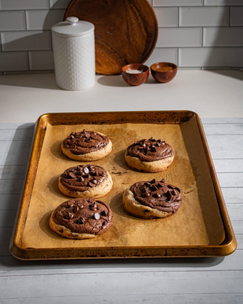 Freshly baked brookie cookies cooling on a baking sheet