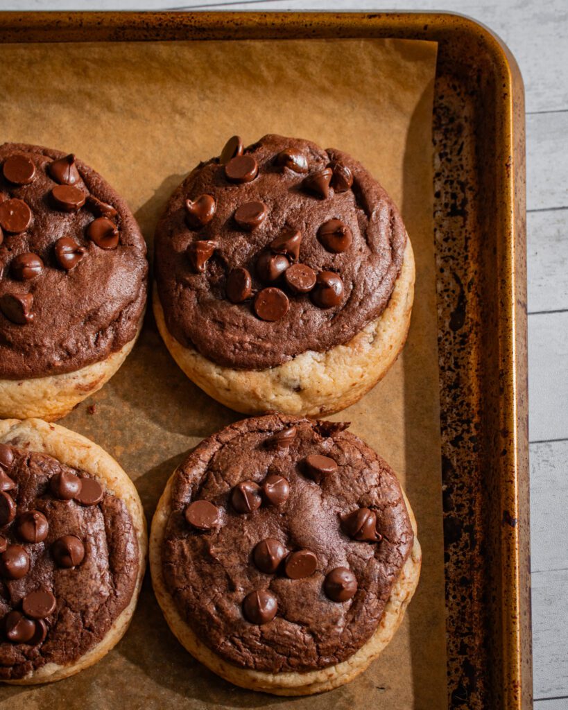 Freshly baked brookie cookies cooling on a baking sheet