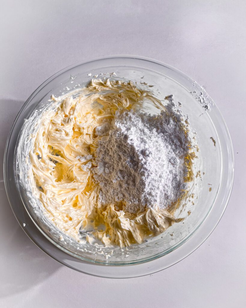Mixing cream cheese and powdered sugar for blueberry frosting