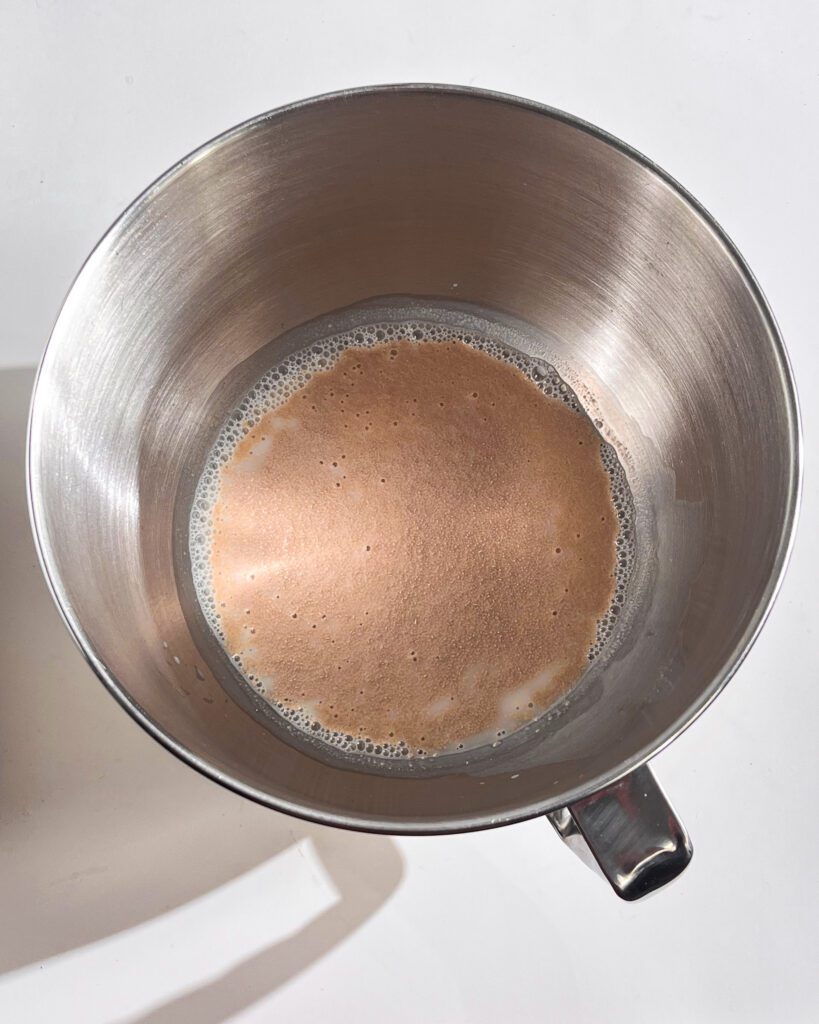 Mixing warm milk with yeast for cinnamon rolls