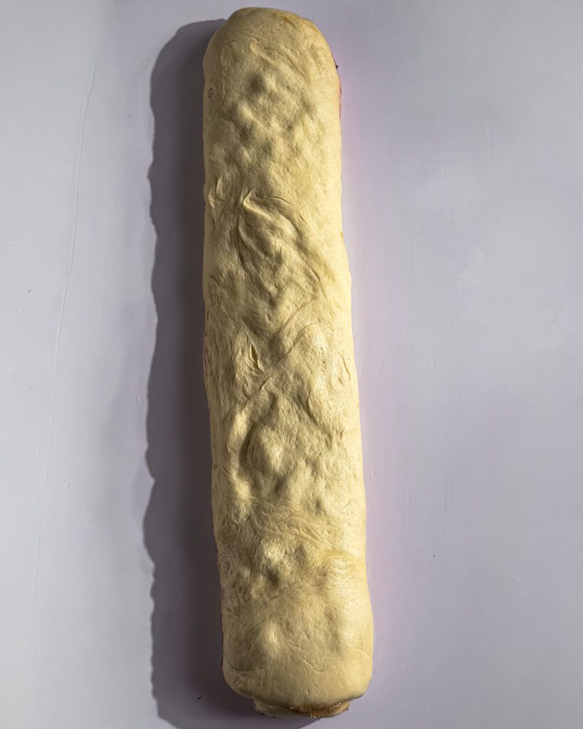 Rolling blueberry cinnamon roll dough into a log
