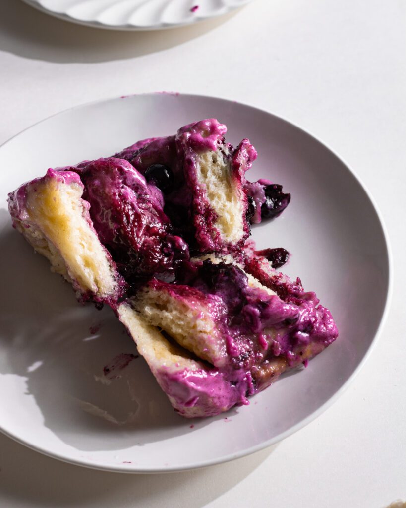 Sliced blueberry cinnamon roll showing gooey center