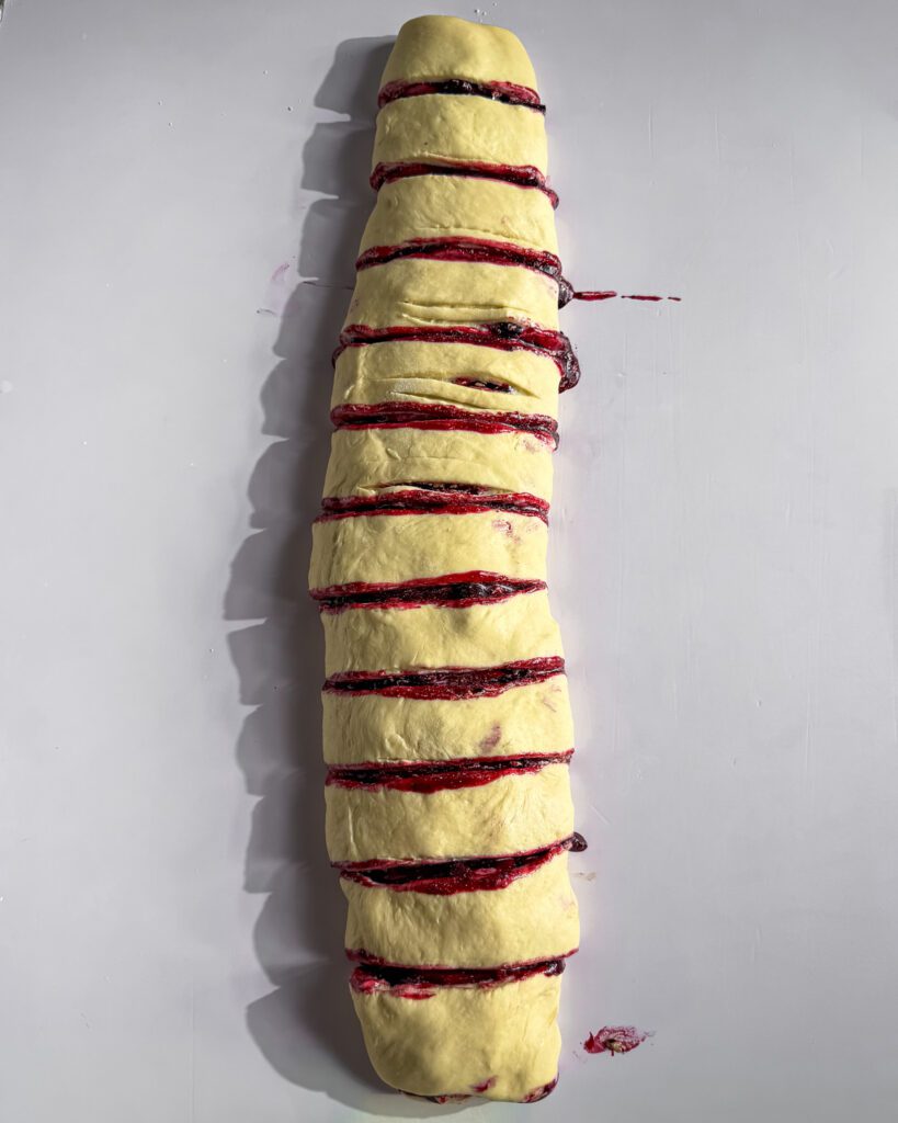 Slicing blueberry cinnamon rolls into individual rolls