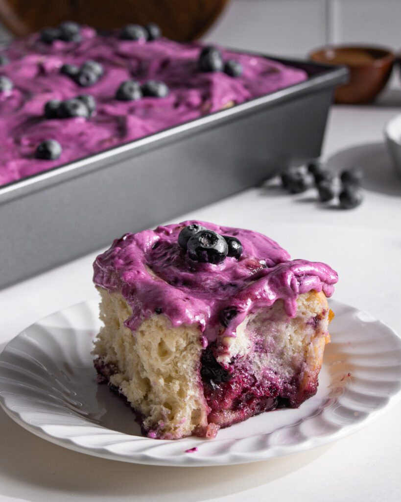 Soft and gooey eggless blueberry cinnamon rolls served on a plate