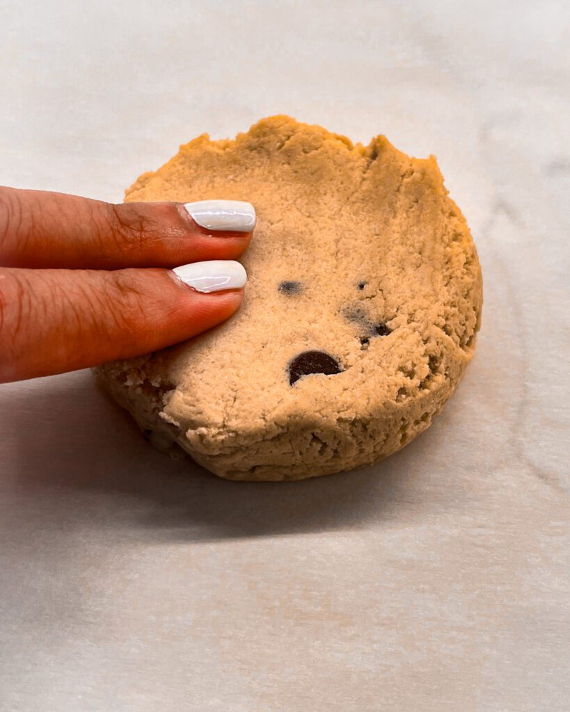 Flattening cookie dough into a thick disc