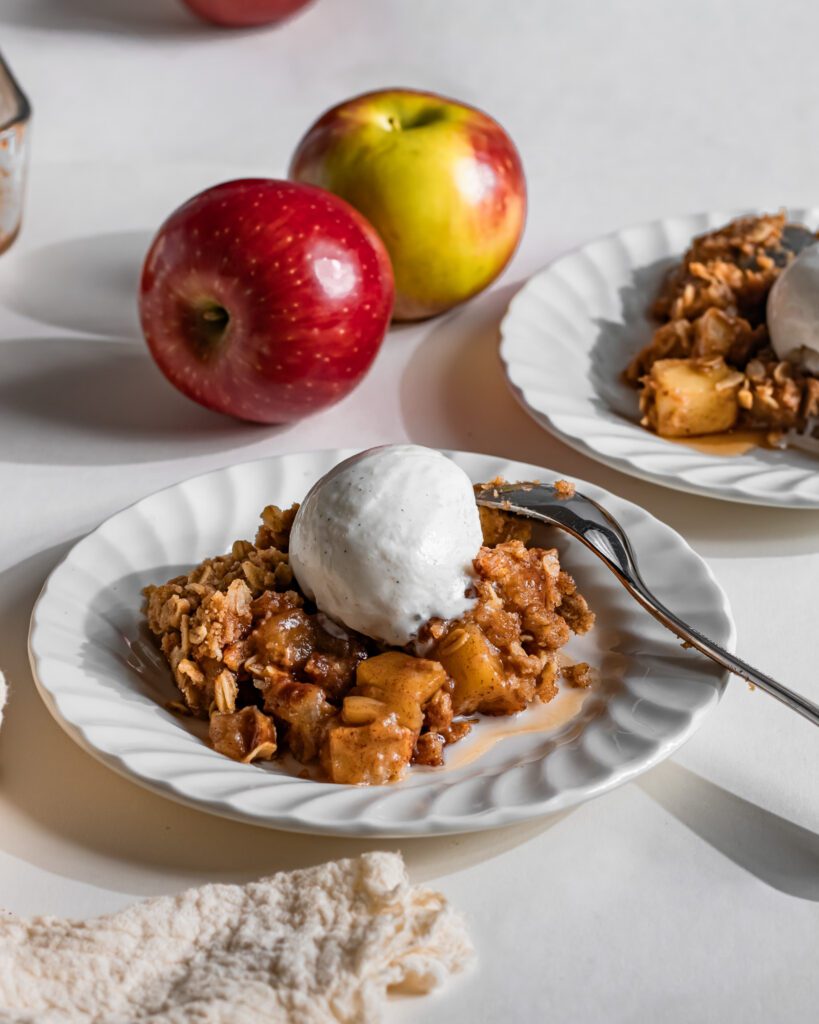 Warm apple crumble served with a scoop of vanilla ice cream
