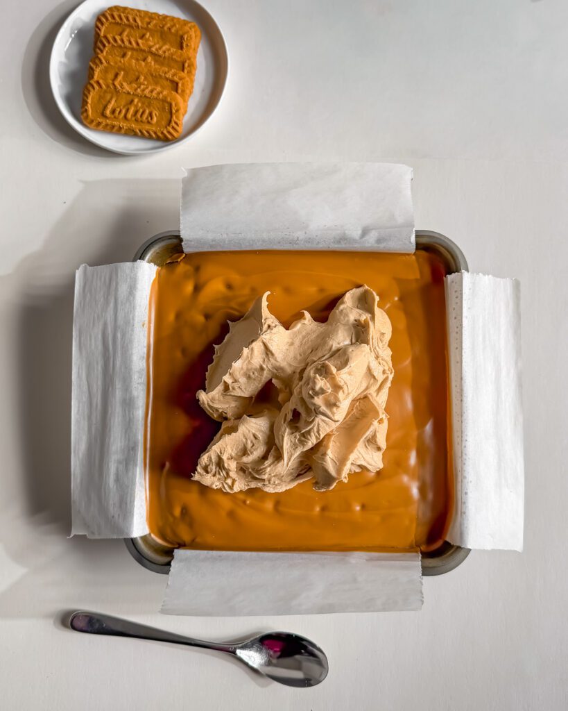 Biscoff buttercream spread over the cookie butter layer of a chocolate cake