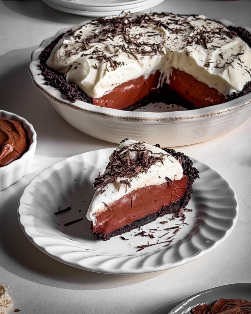 No-bake chocolate cream pie with a chocolate cookie crust, creamy eggless chocolate custard, and fluffy vanilla whipped cream